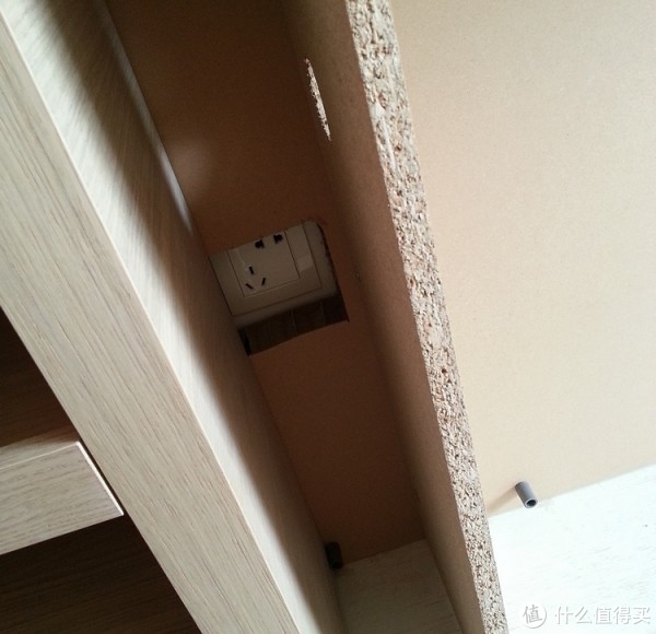 在床头柜背板上挖洞把插座露出来