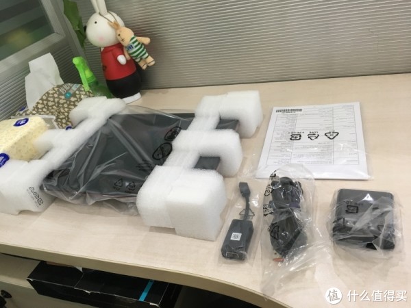 机子用泡棉卡着，边上左到右是Micro HDMI转VGA、电源线、电源头