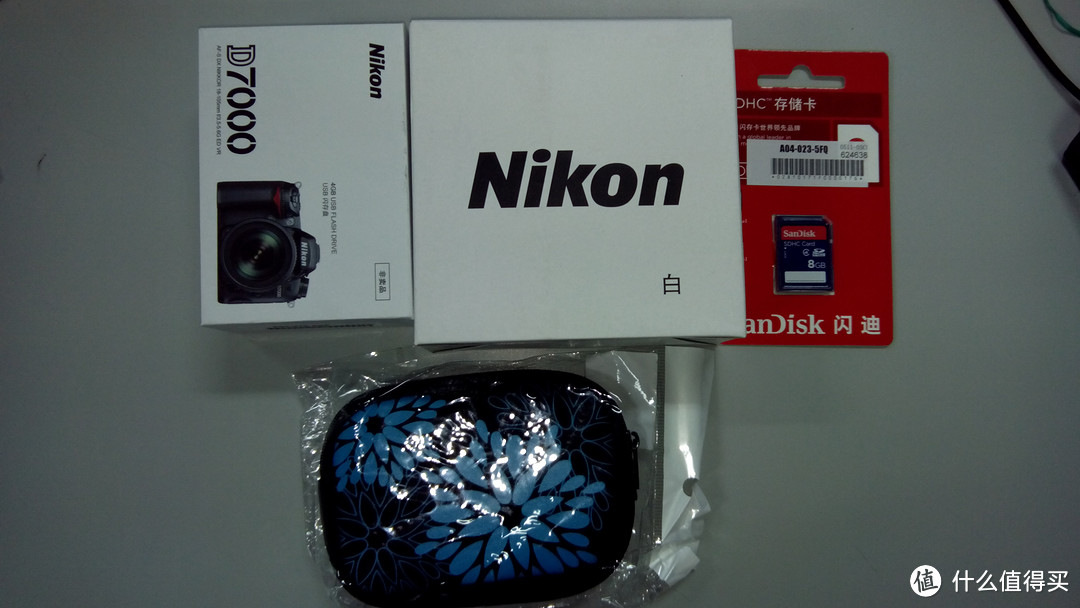 送的4大件，2件是尼康品牌的小赠品，USB电风扇和D7000造型的相机U盘（4G)。另外是sandisk的8G卡和相机包。