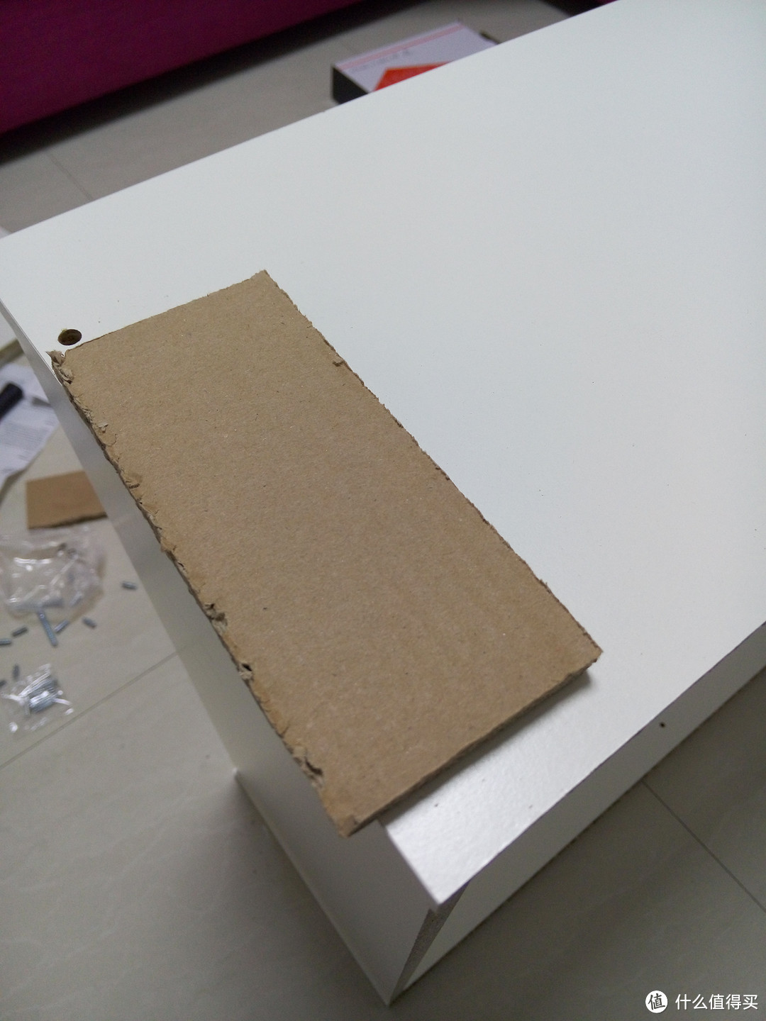 垫上包装箱中的纸板轻轻敲打下板材，保证安装到位。