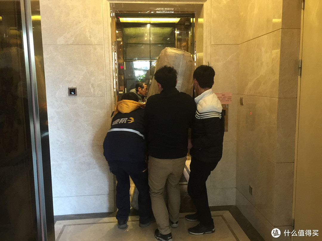 机智的物业小哥指点把外包装拆除后将床垫弯曲,终于顺利的装进了电梯