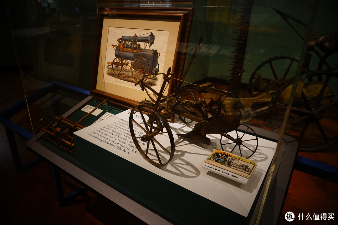 犁地机模型，左边画框里展示了当时已经出现依靠蒸汽机为动力来源的农业机械。右下角是流行于当时的迷你广告卡。
