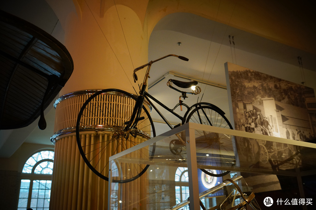 19世纪末，曾经流行的大轮自行车逐步被眼前这种前后车轮一边大的新式自行车所取代。以往的大轮自行车虽然制造简便，价格低廉，但其非常容易倾斜，骑行也不够舒适。新型自行车骑行方便，道路适应能力更好，也更安全。这里挂着的是1889年生产的Pope哥伦比亚安全自行车。