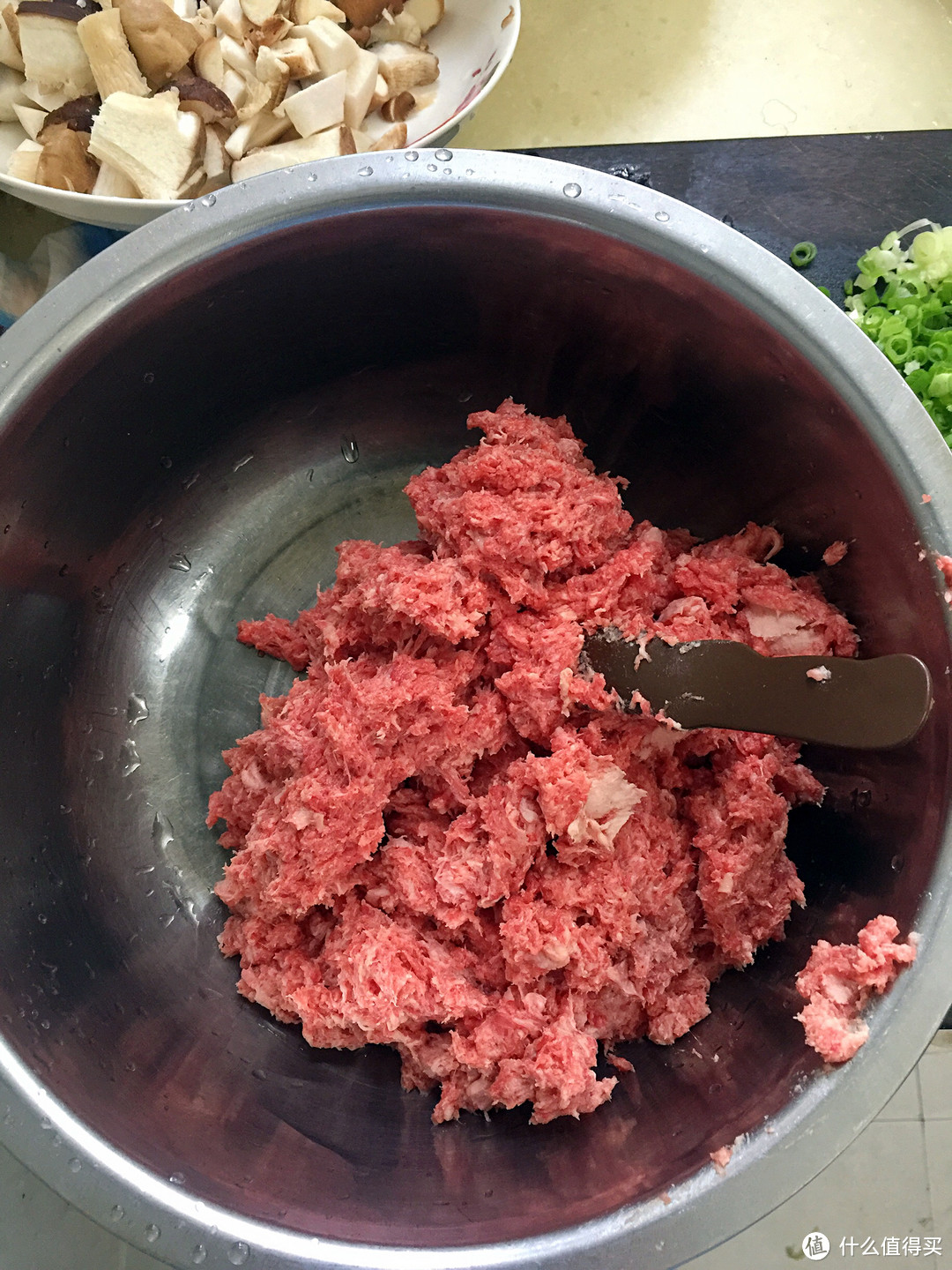 绞好的肉倒入盆里，准备绞香菇。