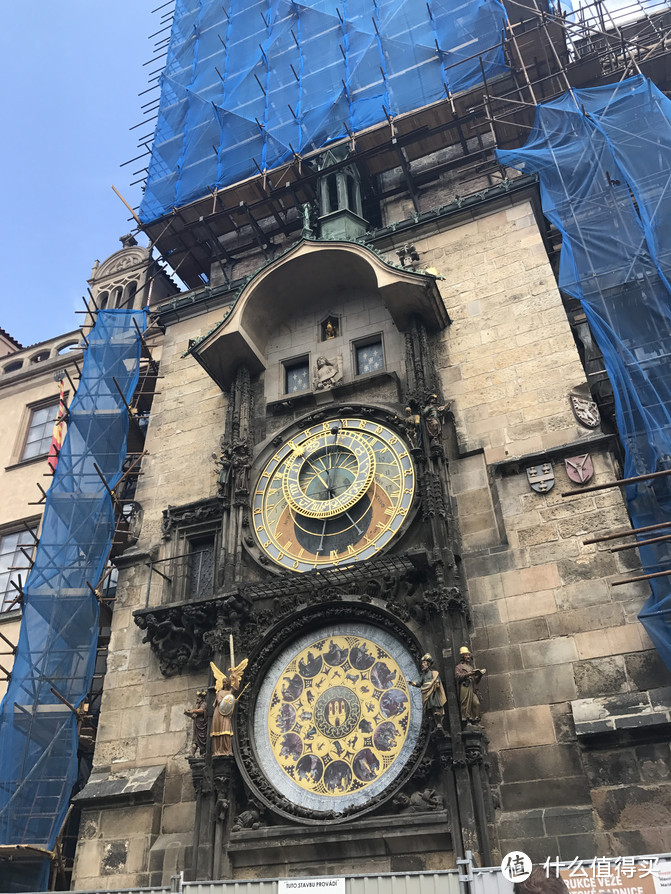 照片描述：布拉格天文钟，位于老城市政厅的哥特式钟塔上（我们来的时候钟塔正在修缮，但天文钟还可以看得到）属于捷克哥特式科学和技术的登峰造极之作，是豪华壮观的艺术古迹。分为上下二层，是一座精美别致的自鸣钟，根据当年的地球中心说原理设计，上面的钟一年绕一周，下面的一天绕一圏，每逢正点都会有骷髅拉动时间、圣徒现身、雄鸡鸣叫等各种报时。