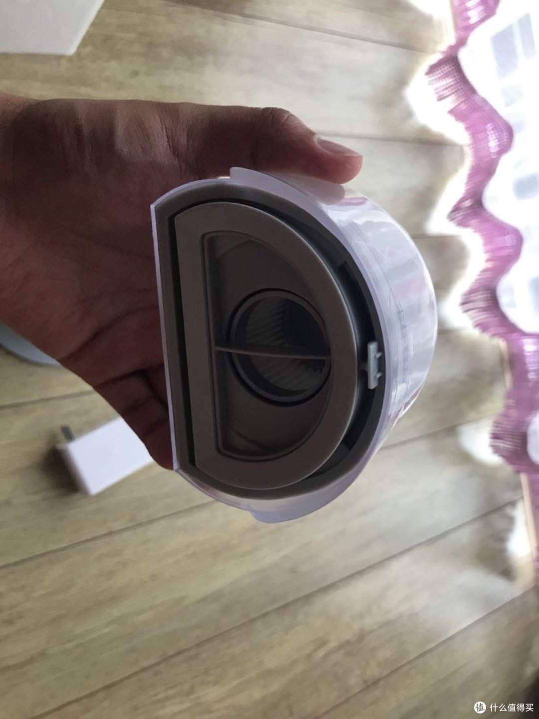尘盒背面，有一个拉手可以取出里面的集尘网