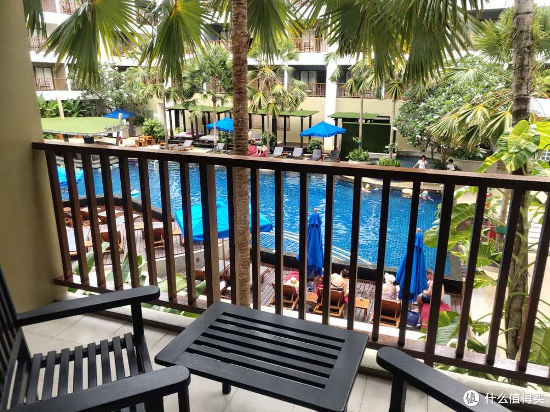 阳台上有两把椅子，整个酒店的房间都可以看到游泳池