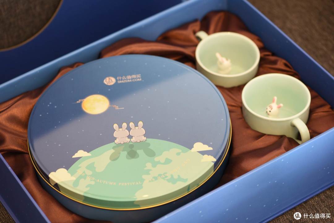 打开礼盒，金属材质的月饼包装盒很显档次，也让我想起了小时候经常吃的饼干，以前经常眼巴巴的看着这种马口铁盒，想偷吃里面的糖果糕点，现在可以随时大快朵颐了。除了铁盒包装月饼，两个和铁盒表面赏月的两只小兔几交相辉映的小兔几杯子，也很有特色，可以和心爱的人一起分享。