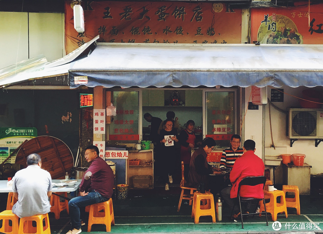 熟客坐在门口打牌，老板娘会把饭端到桌前