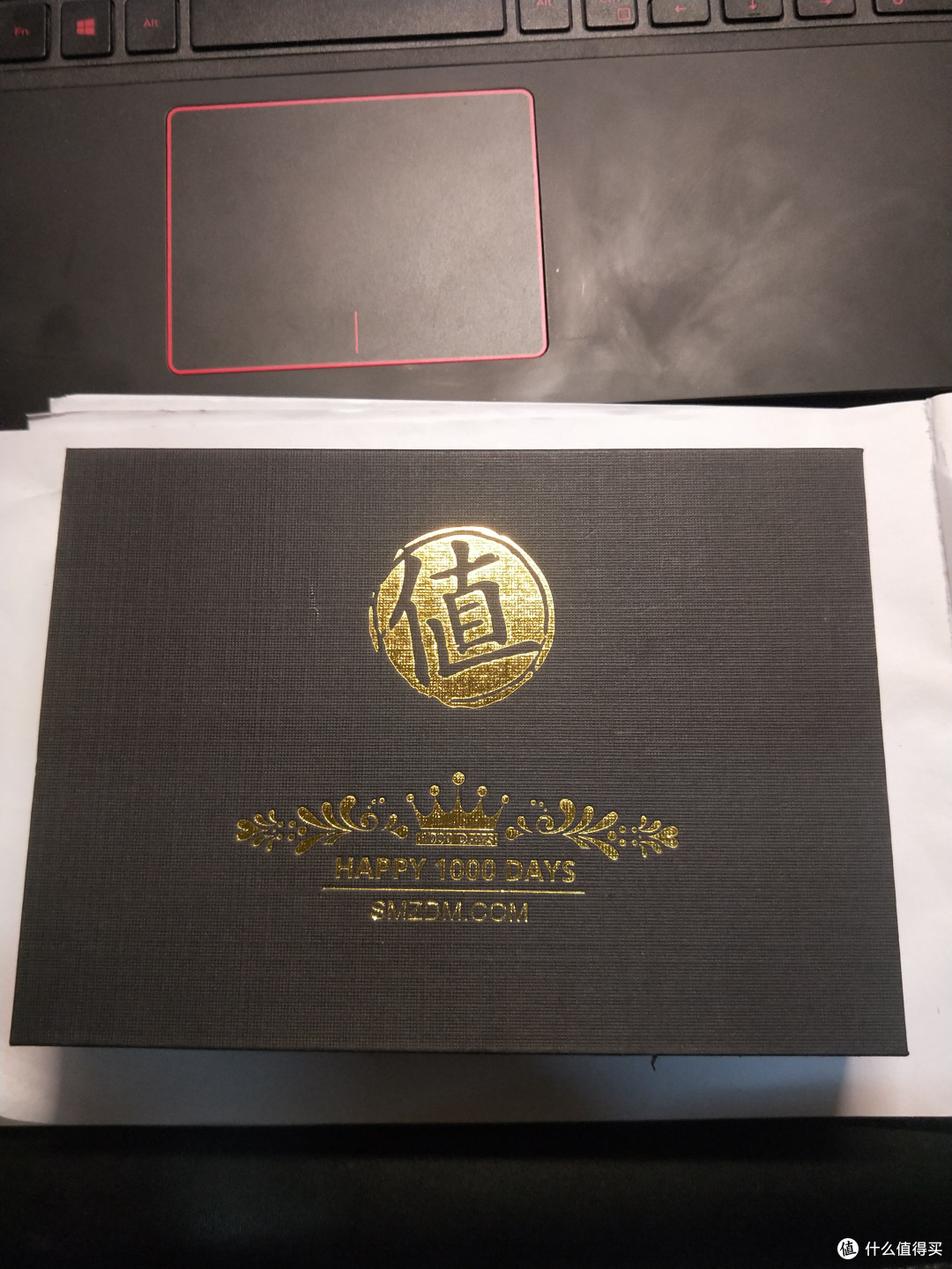 然后我们打开快递盒子，上面一个大大的“值”，下面一个皇冠，1000天和SMZDM的网址，黑金配色挺好看的