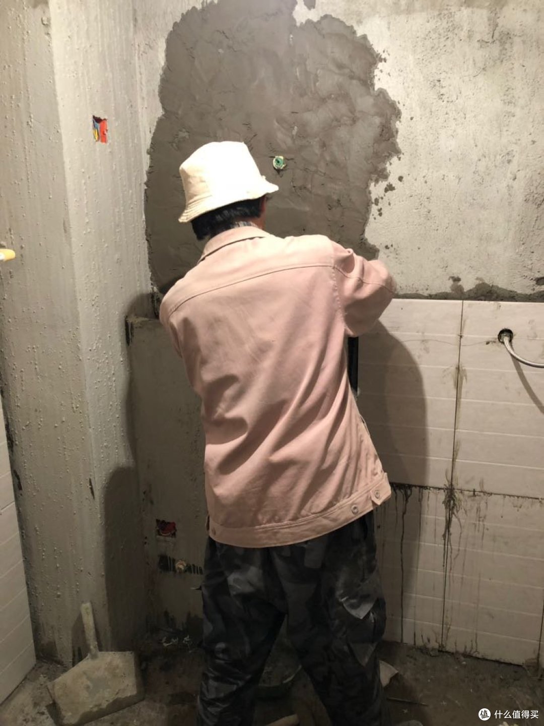 瓦工师傅在给假墙贴瓷砖