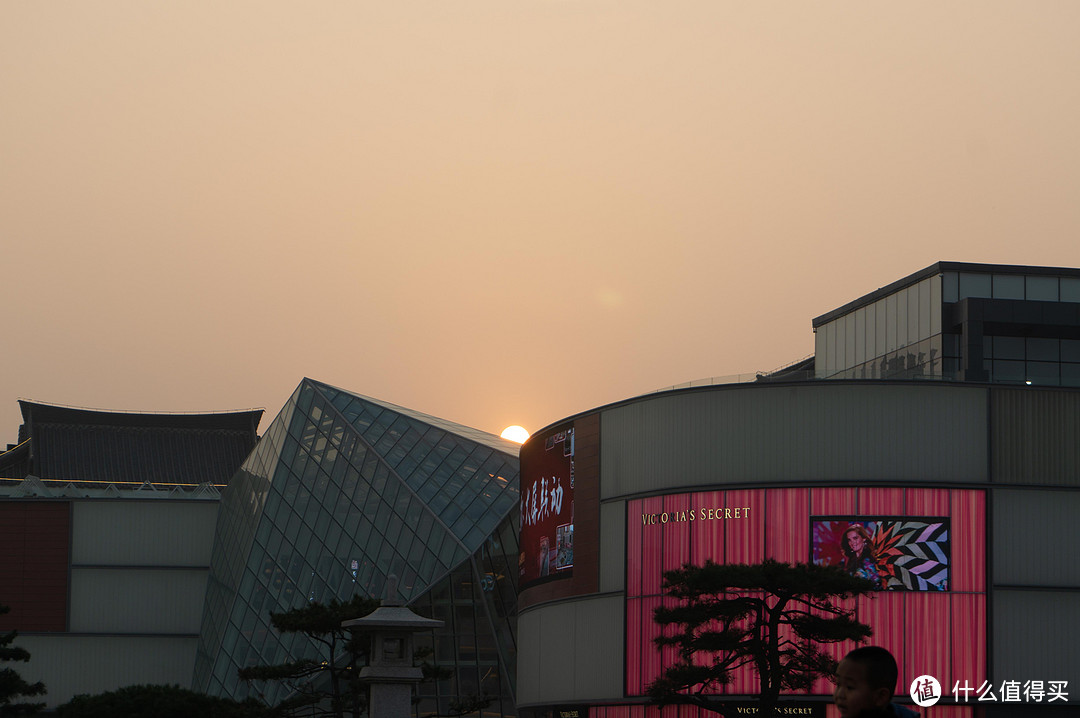 1/250 f7.1 iso100这是有名的打卡地：大悦城。时近黄昏，决定拍一张夕阳。这是预设的自动模式。虽然天空泛黄，建筑的细节也还算丰富，但是明显欠缺一点夕阳西下的意境。切换到夕阳模式拍一张，见下图。