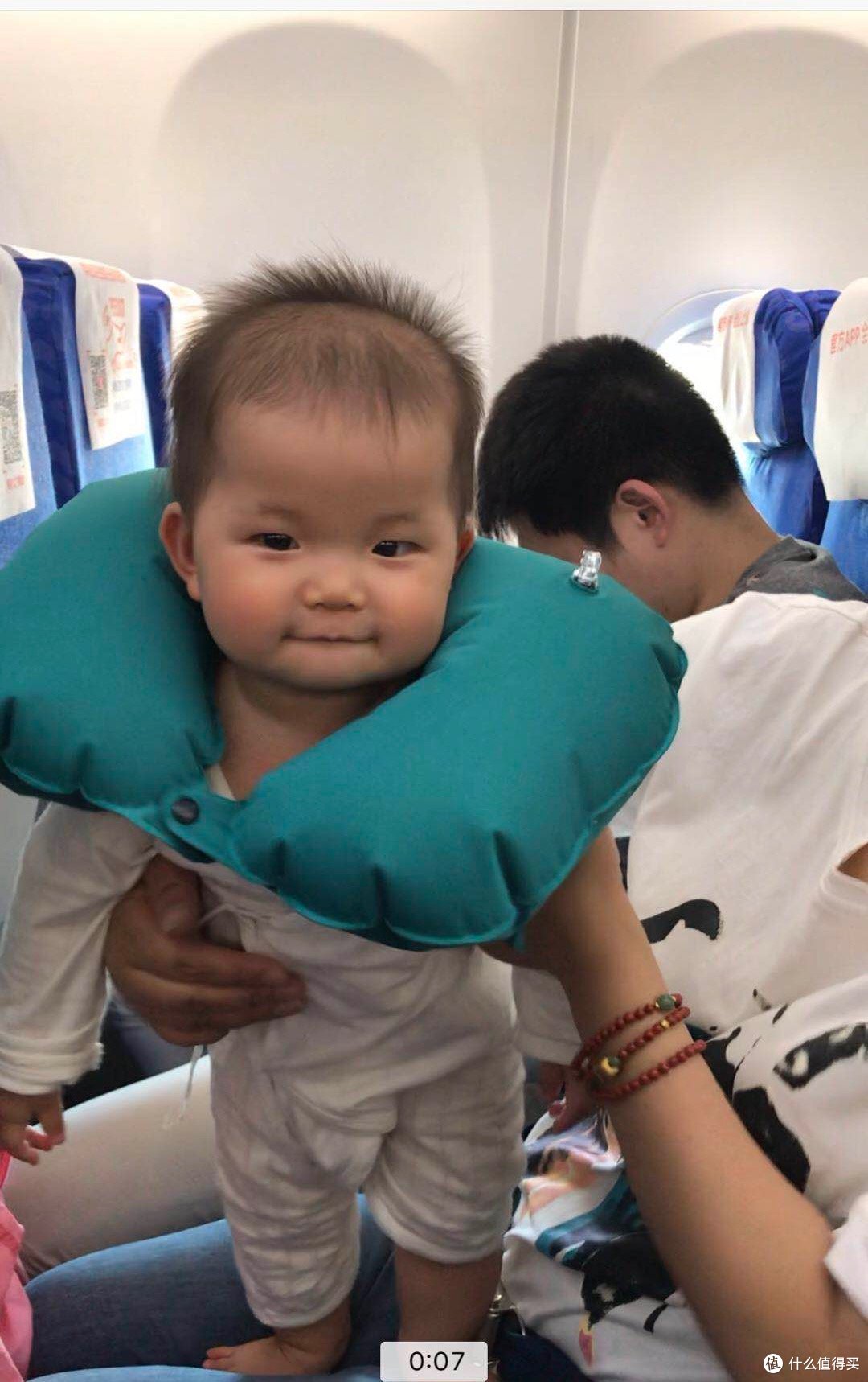 飞机上,卷卷除了睡觉,基本就是这个状态【图片为视频截图】