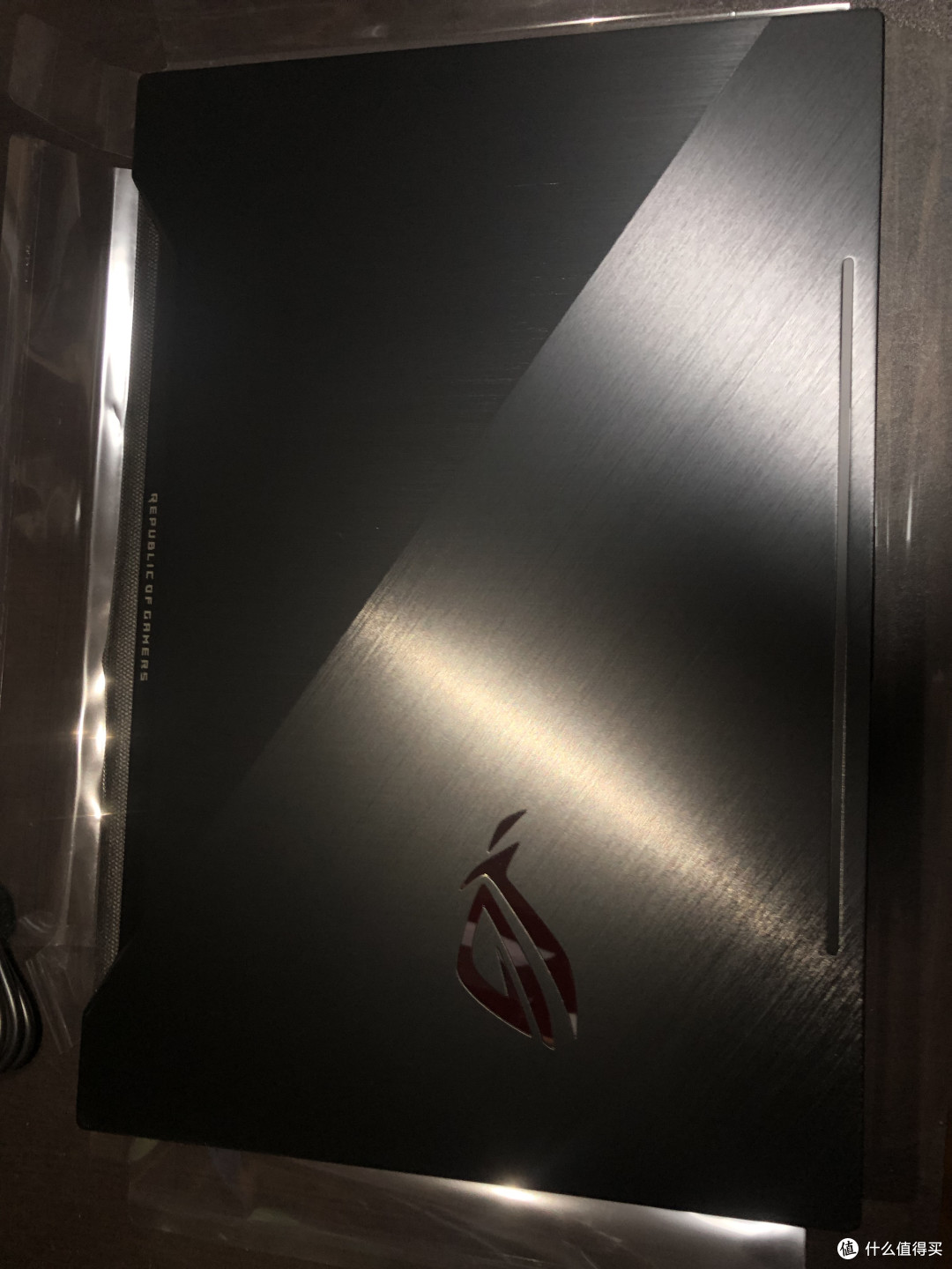 A面是金属外壳，保障电脑的整体强韧度，壳面两种直线纹路从中间间隔开来，镜面的LOGO会在电脑开启后发出红光