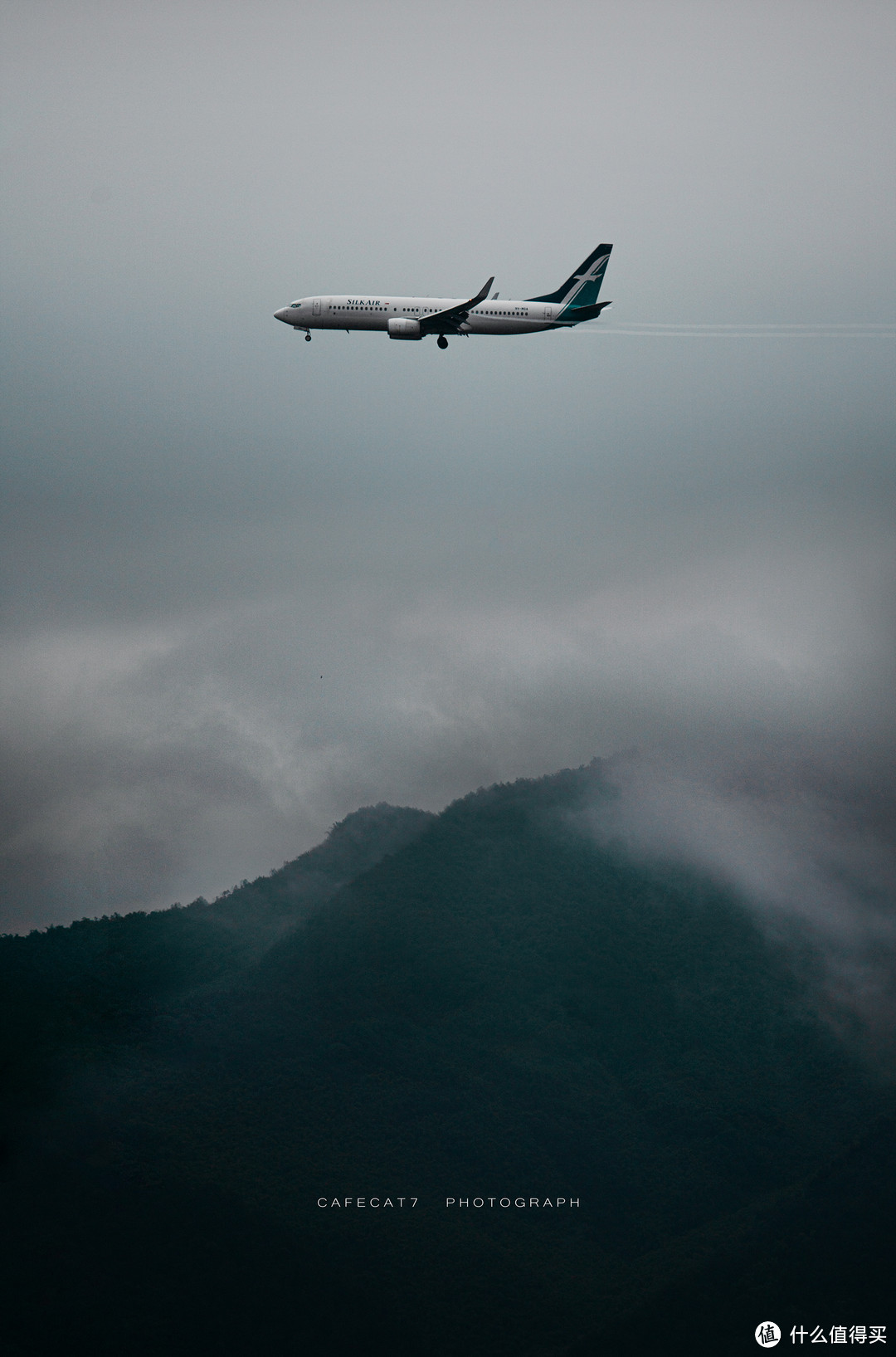 暴雨过后，远山云雾缭绕，一架准备降落的胜安航空的班机。