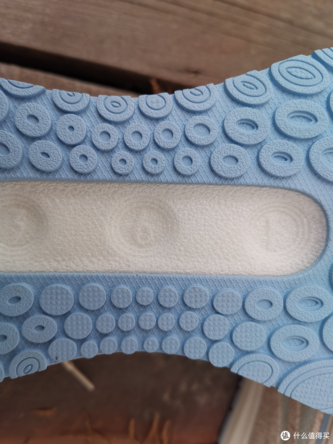 在跑鞋的中间位置，则是一块镂空设计，白色的中底上面浮雕出“361°”的品牌LOGO。