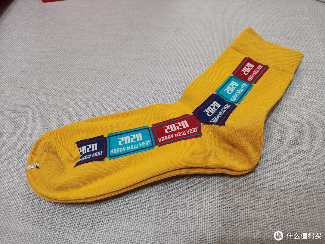 袜子是中筒的，黄色这款叫做2020，整个袜子侧面是三种颜色的方块，每个里面都写着2020happy new year
