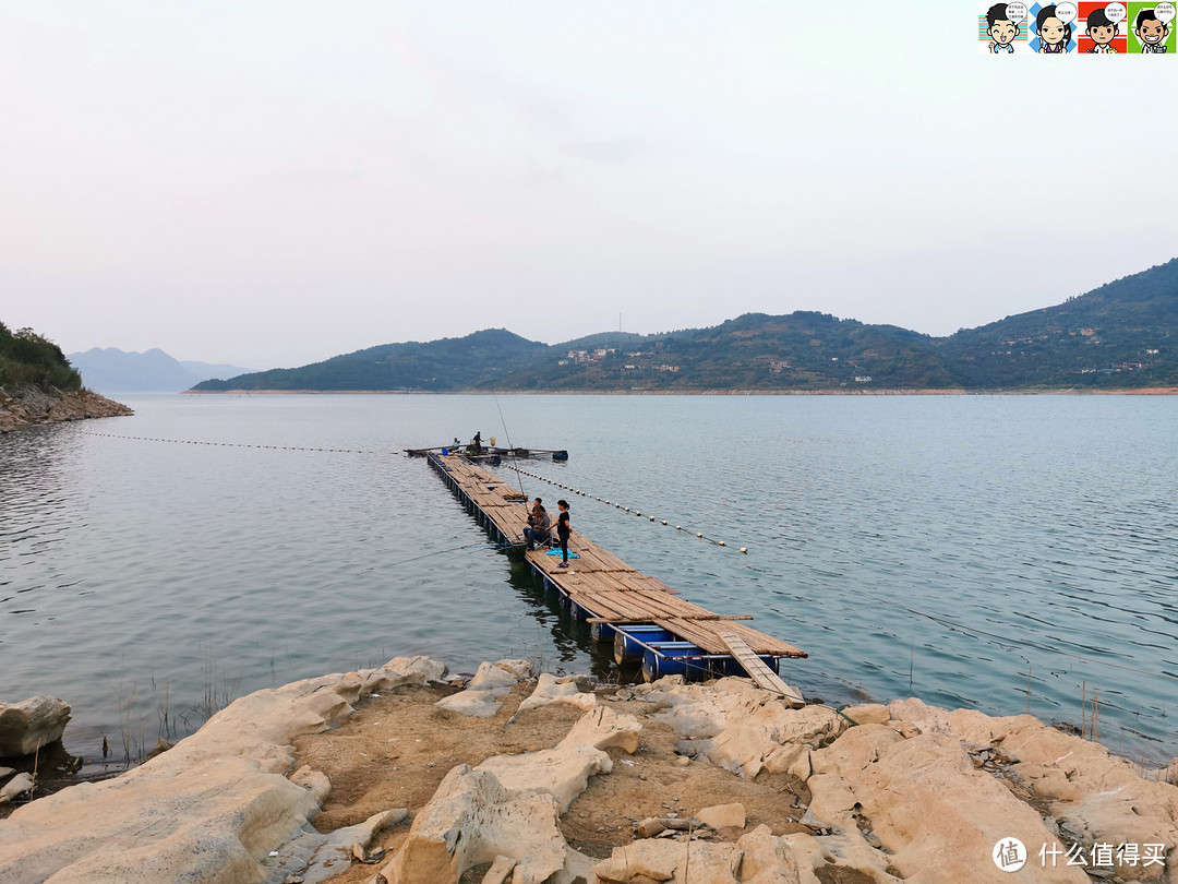 湖上用胶桶和竹板铺设了一道浮桥，桥上有人在垂钓。