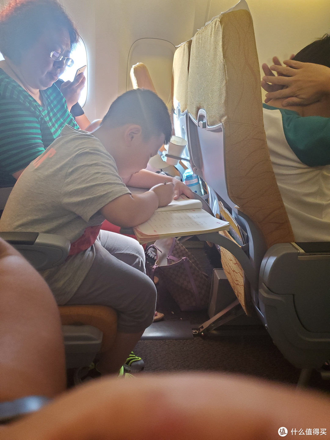 邻座的小朋友回国的飞机上在写作业