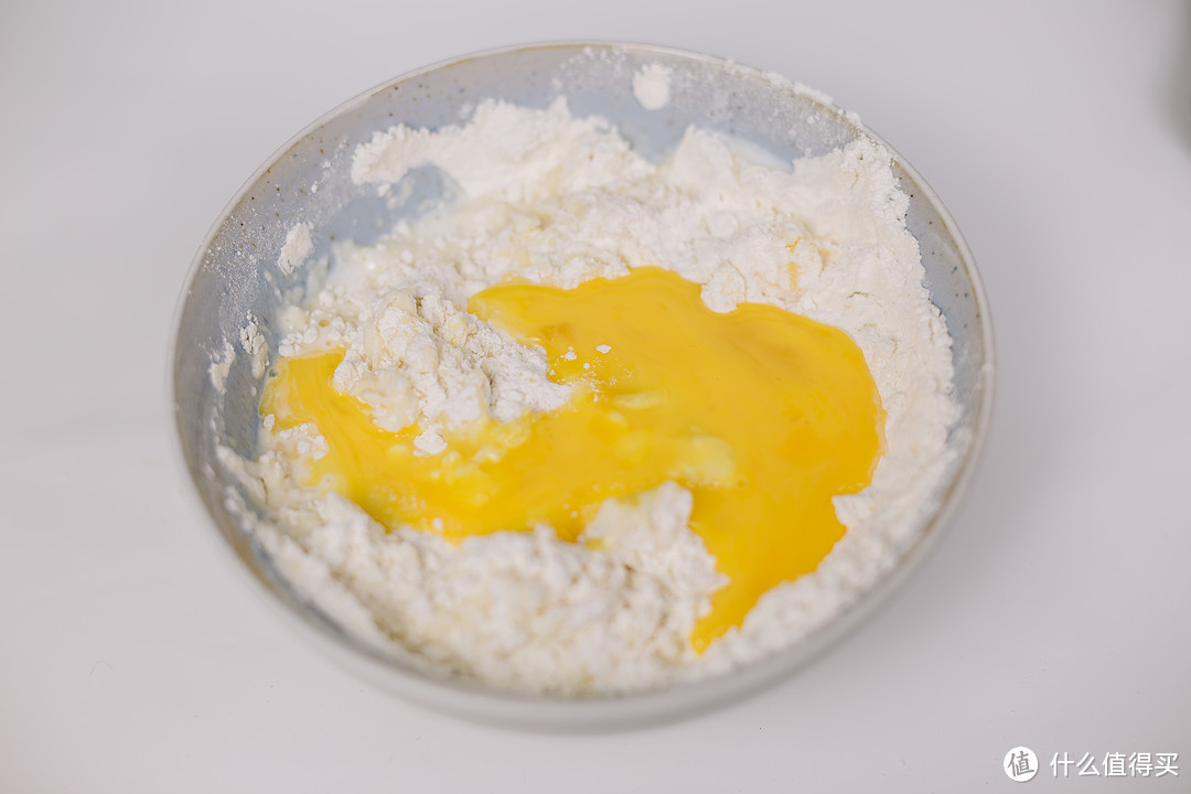 加入鸡蛋农业混合均匀，留一点刷司康的表面，再加入牛奶混合成面团
