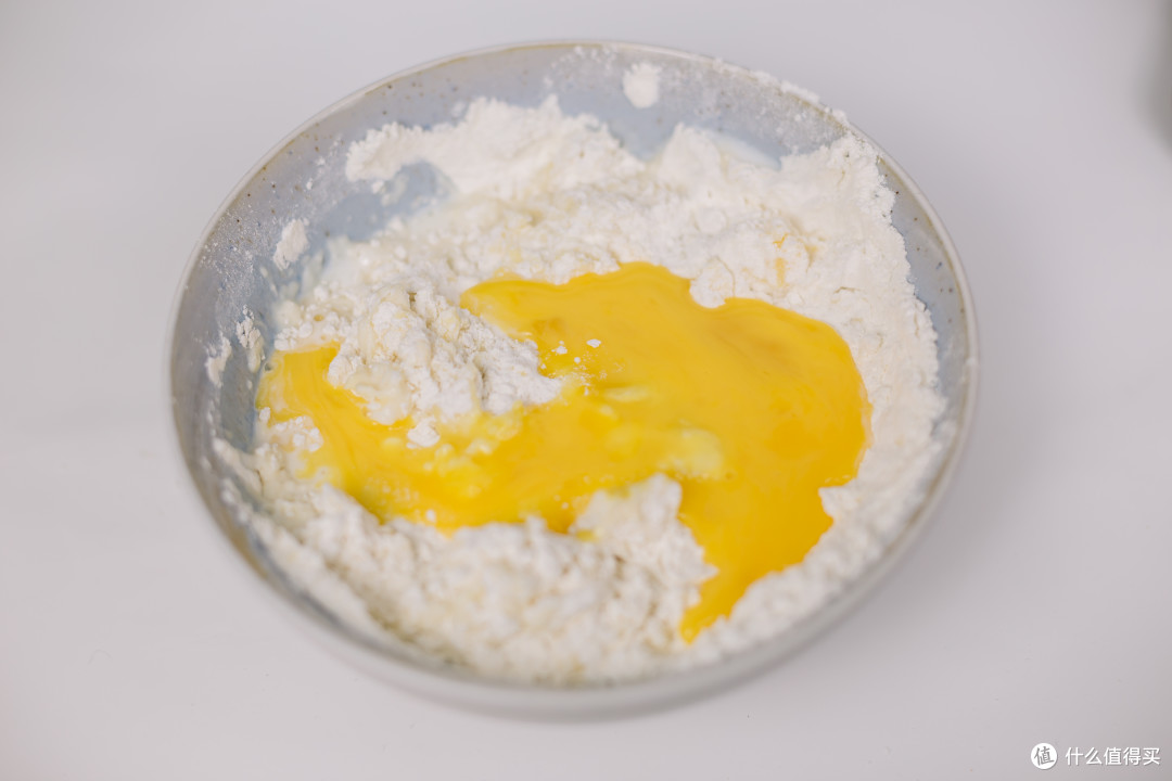 加入鸡蛋农业混合均匀，留一点刷司康的表面，再加入牛奶混合成面团