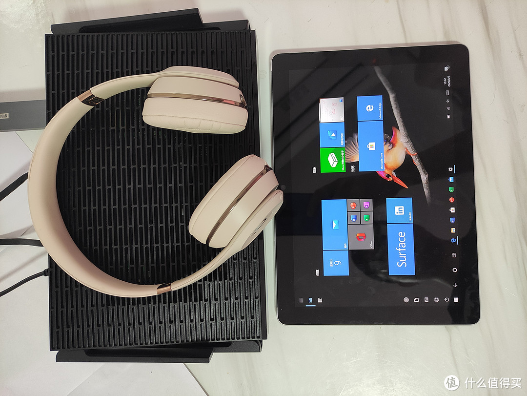 Linksys MR9600与Surface Go的大小对比，与Beats Solo Soundwireless3的对比