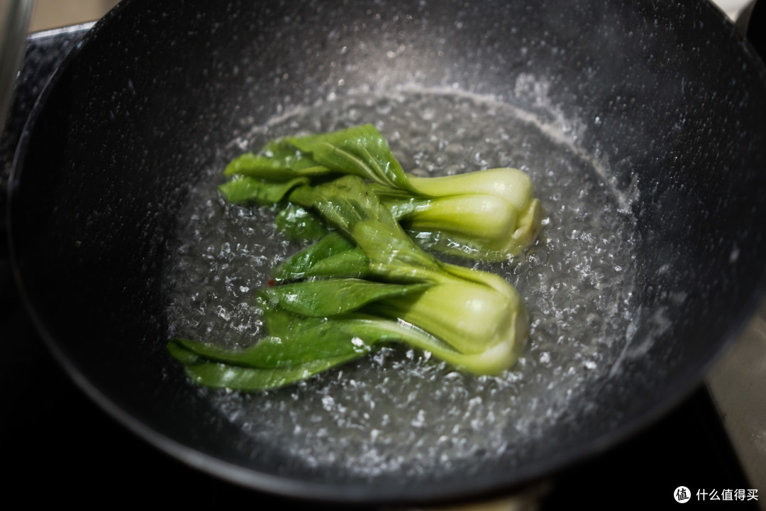 不要刷锅，加入开水和盐，把油菜放进去煮熟。盐可以给油菜调味并保证它不变色