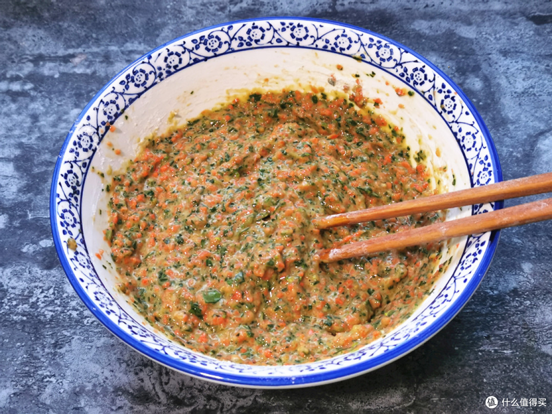把胡萝卜和菠菜碎倒入大碗中，打入2个鸡蛋，撒上盐和五香粉搅匀，再分次倒入面粉，用筷子搅成浓稠的面糊状；