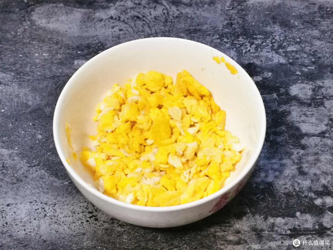 锅中倒入花生油烧热，鸡蛋在碗中打散，把蛋液倒入锅中，炒至凝固后划散成小块，关火倒入碗中晾凉；