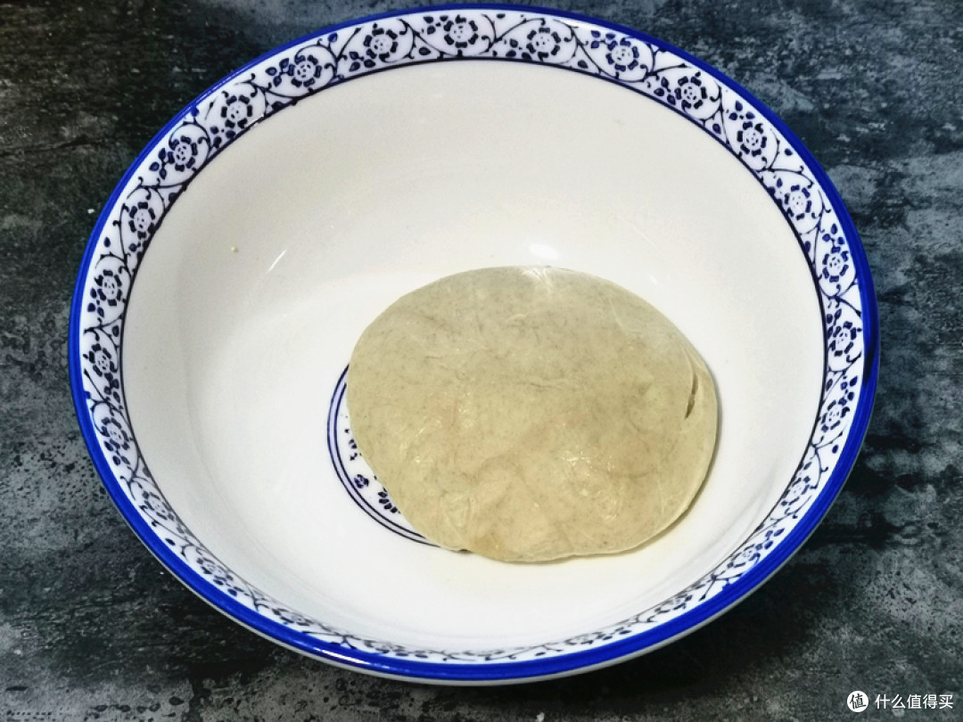 面粉倒入大碗中，慢慢倒入温水，边倒边用筷子搅至絮状，再下手揉成光滑的面团，盖上盖子醒半个小时；