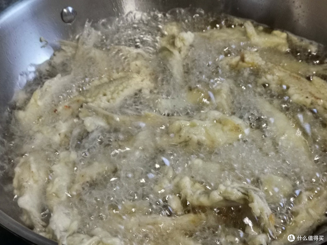 等炸至定型后，用筷子翻动一下，炸至表面金黄捞出沥油，同时升高油温至八成热；