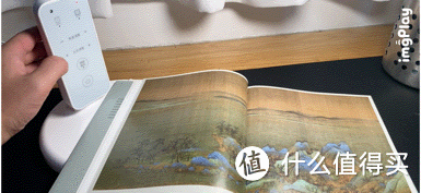 可以明显看到，桌面上的《千里江山图》的眼色随着光线的调整而在发生不同的变化。
