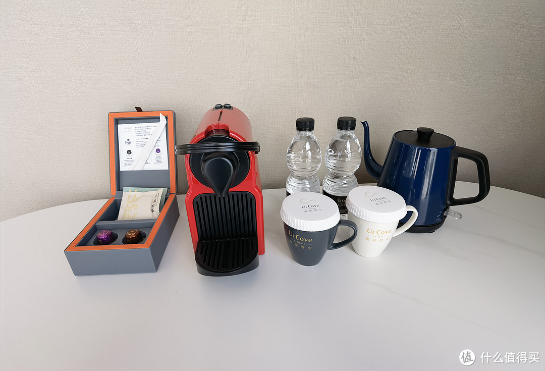 电热水壶、两个杯子、胶囊咖啡机，带有酒店名字的饮用水