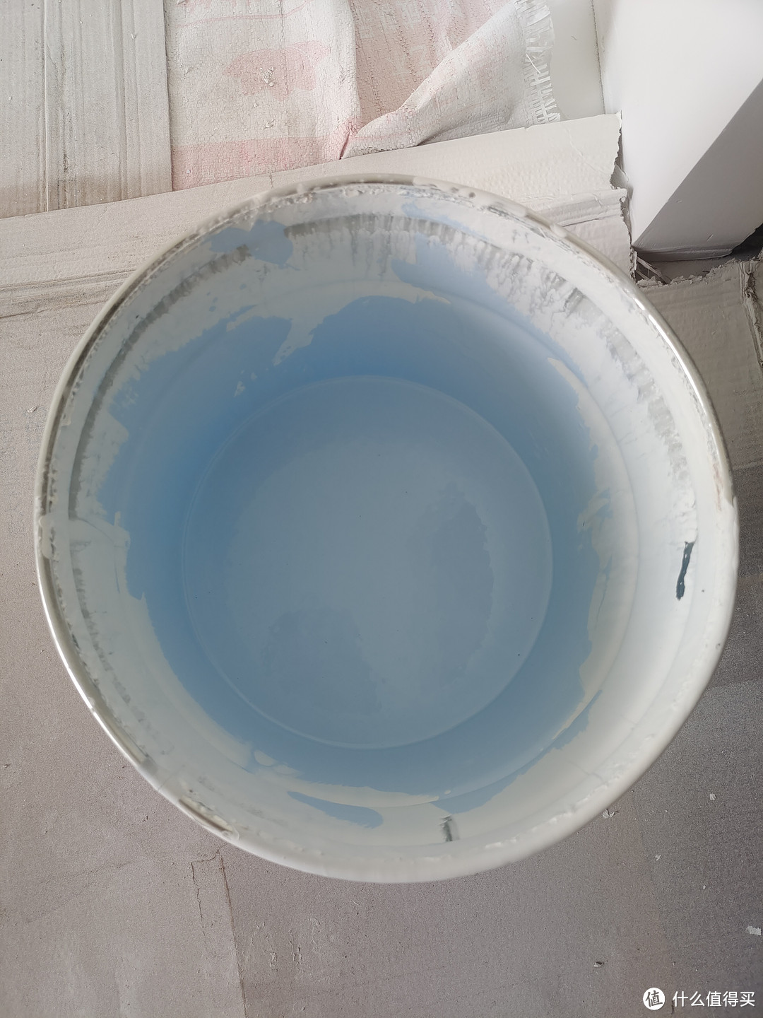 ▲将色漆倒进能塞进滚筒的大桶，兑一点点水，兑水量不要超过色漆总量的20%