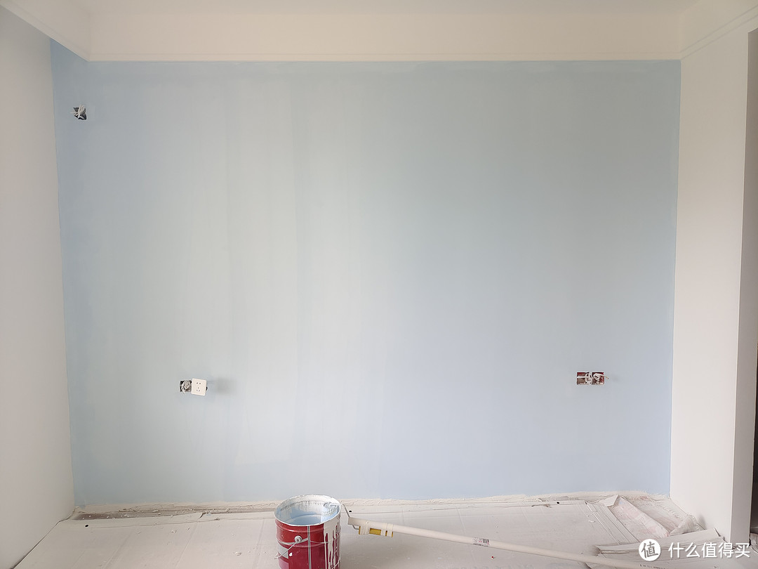 ▲再用滚筒刷漆从墙面中间开刷，由上及下滚涂，完成第一遍刷漆，可以看到第刷完第一遍后墙面还是挺花的，颜色也比较淡