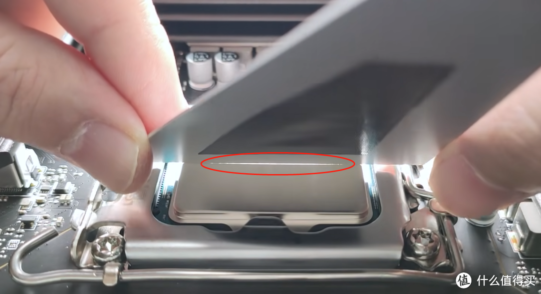 ▲CPU装入扣具的状态，用刮板透光后查看CPU的顶盖出现了向内弯曲的情况