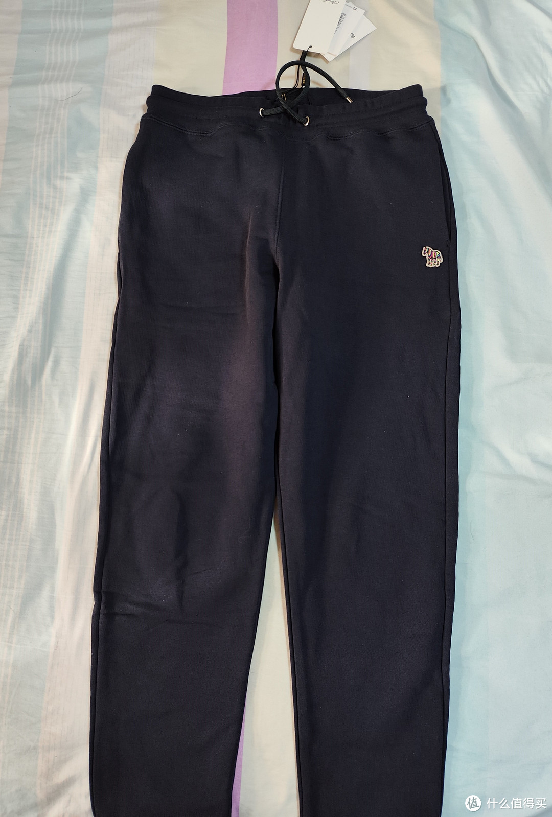 普普通通的深蓝色抽绳运动裤，左袋处有贴标。