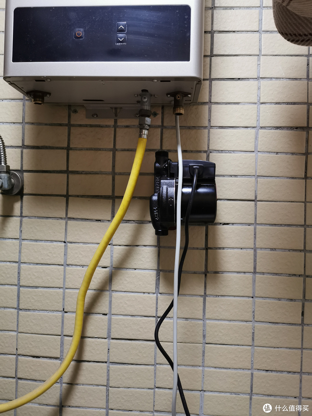 UPA90挂到支架上。这个增压泵挺沉的（包装盒上标的3.7kg），幸好买了专用支架可以上墙，不然吊在热水器冷水入口上我肯定不放心。