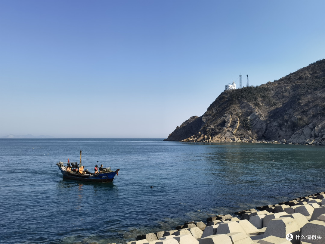 海之韵公园入口处的海边,正在靠岸的小渔船