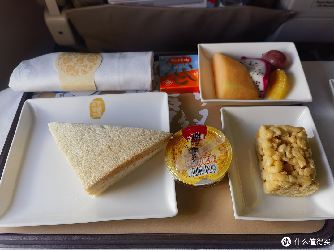 平飞后还是有餐食的，是小点心，包含一个三明治、沙琪玛、水果、枇杷膏、酸角糕