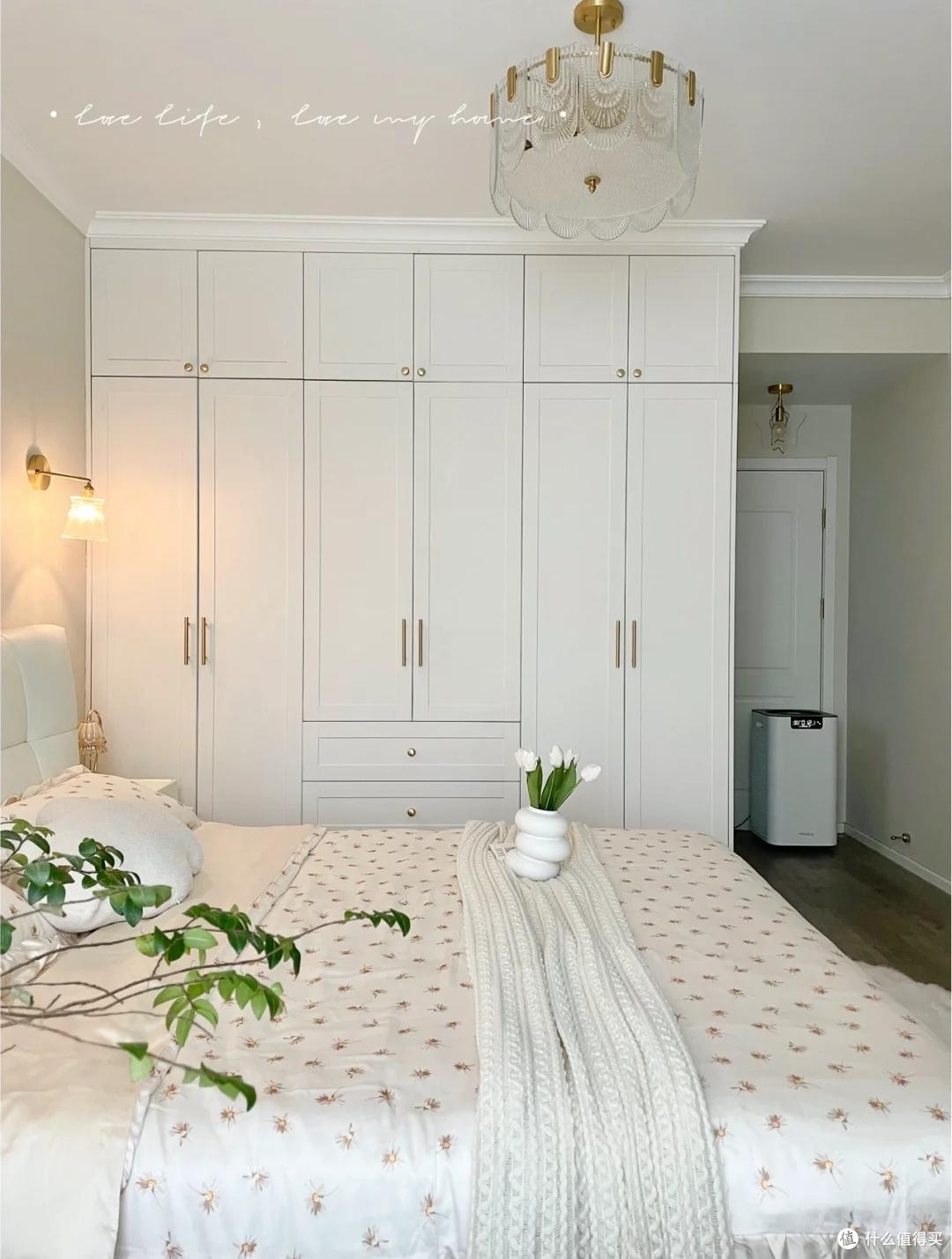 床头背景墙涂刷了奶油色乳胶漆,柔和的色调与白色床