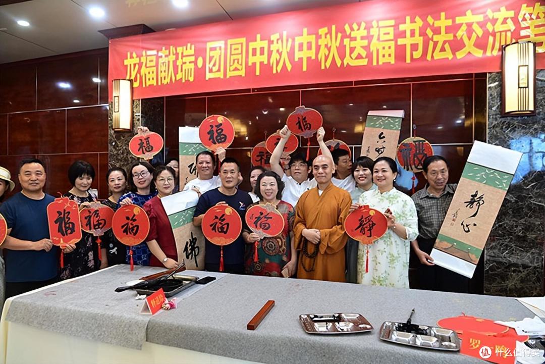 现场嘉宾在中秋送福书法交流笔会现场高举福字，共迎龙年中秋。