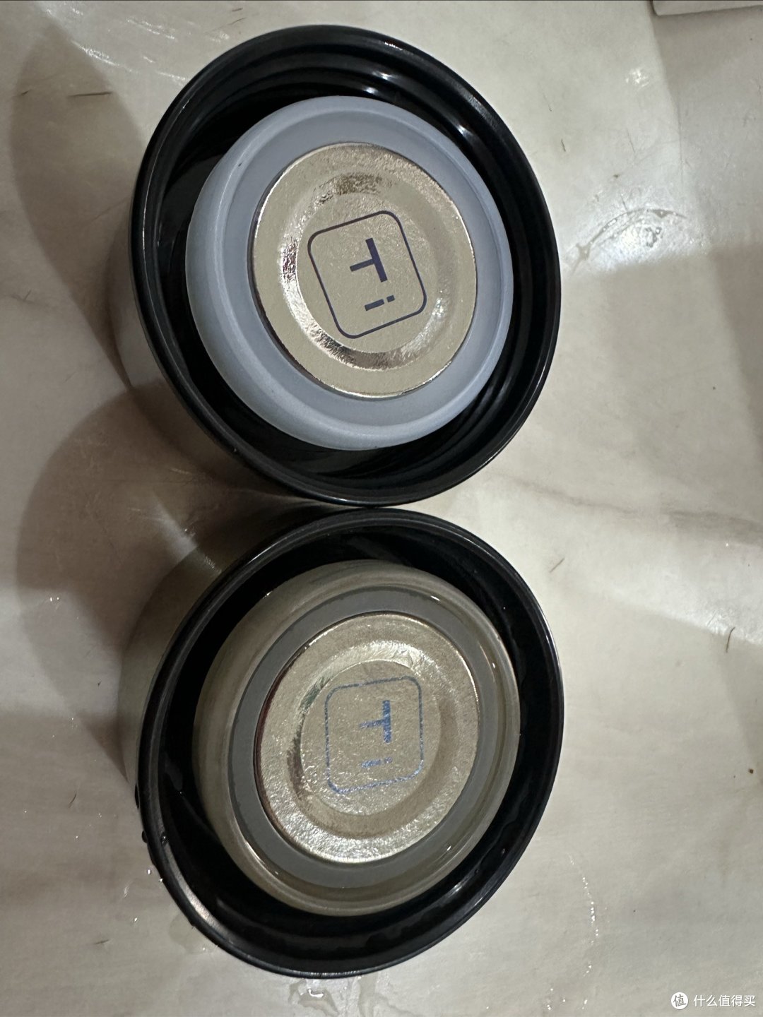 两个杯盖对比：上面是喝水的，下面是泡茶的