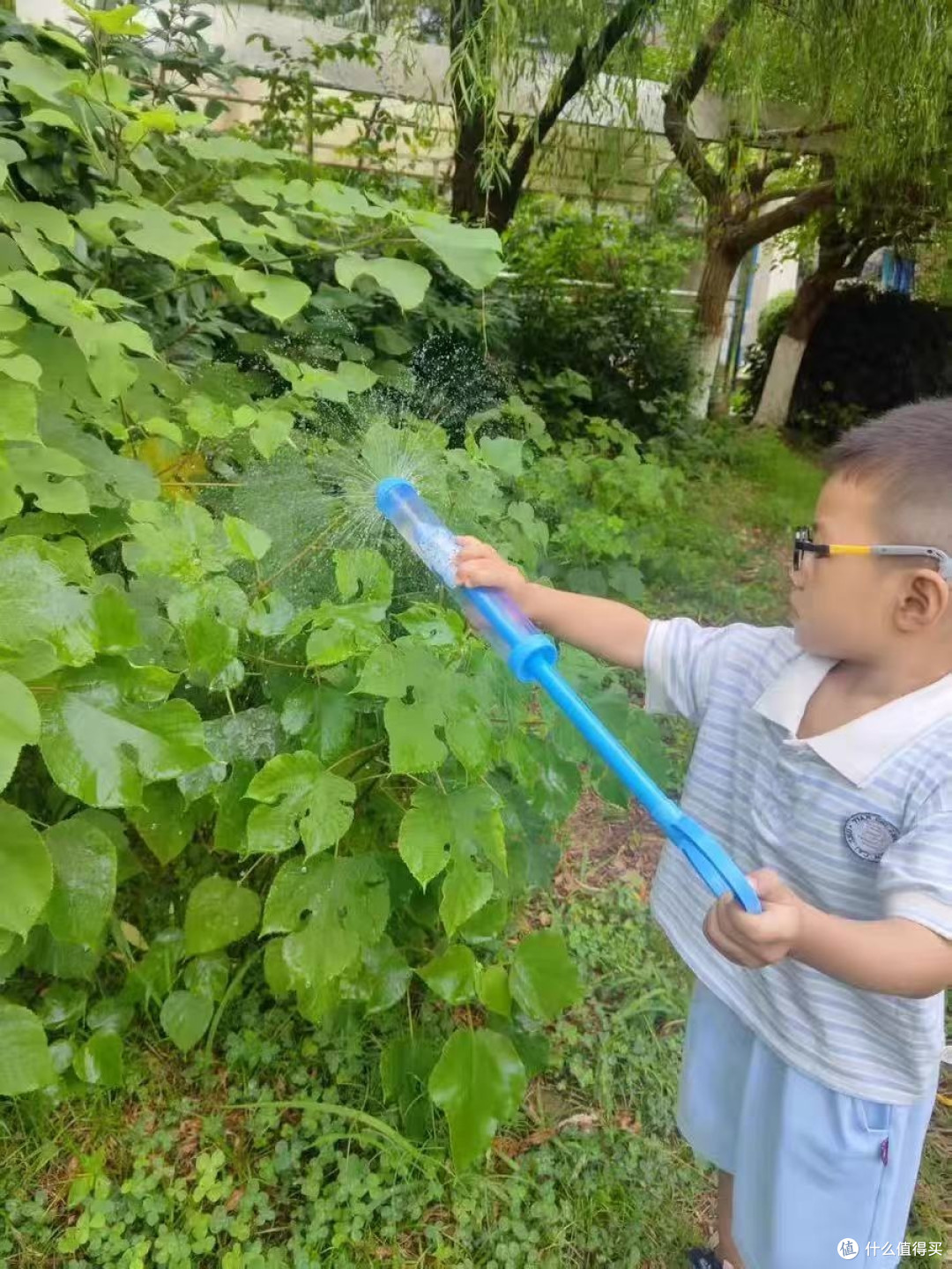 这时妈妈举着个蓝盈盈的东西走过来,塑料壳在阳光下晃眼——是把水枪。