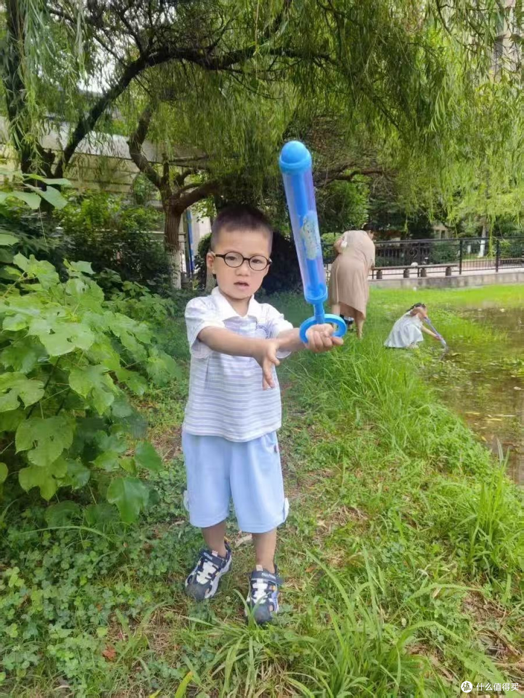这时妈妈举着个蓝盈盈的东西走过来,塑料壳在阳光下晃眼——是把水枪。