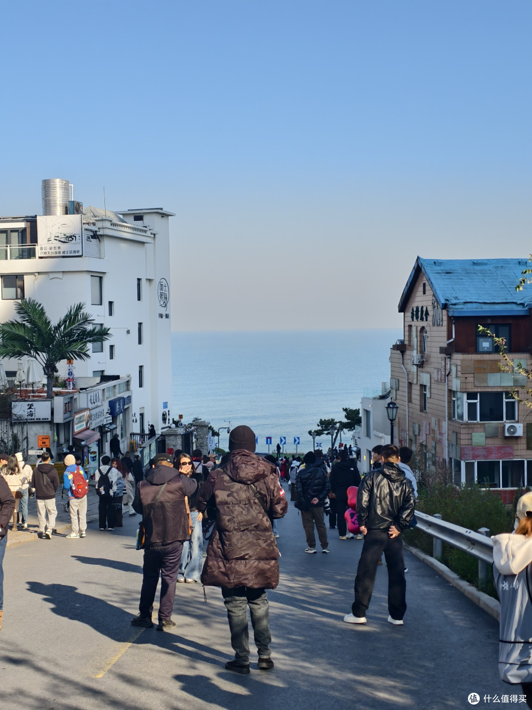 威海火炬八街是威海高新区的网红打卡地，街道呈坡路走向，两侧错落着彩色建筑，白墙蓝顶的小屋搭配热带绿植，极具日系街头韵味。走到街尾便能直面蔚蓝大海，热闹的人群与清新的海景相融，随手一拍都是氛围感大片