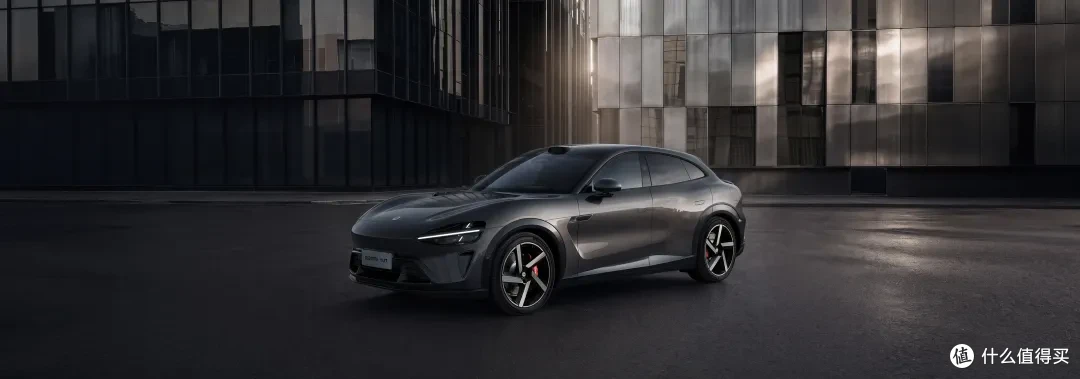A gray sports car is parked on the city street, with modern glass curtain wall buildings in the background. The wheels have red brake calipers, and the overall design looks stylish and dynamic.