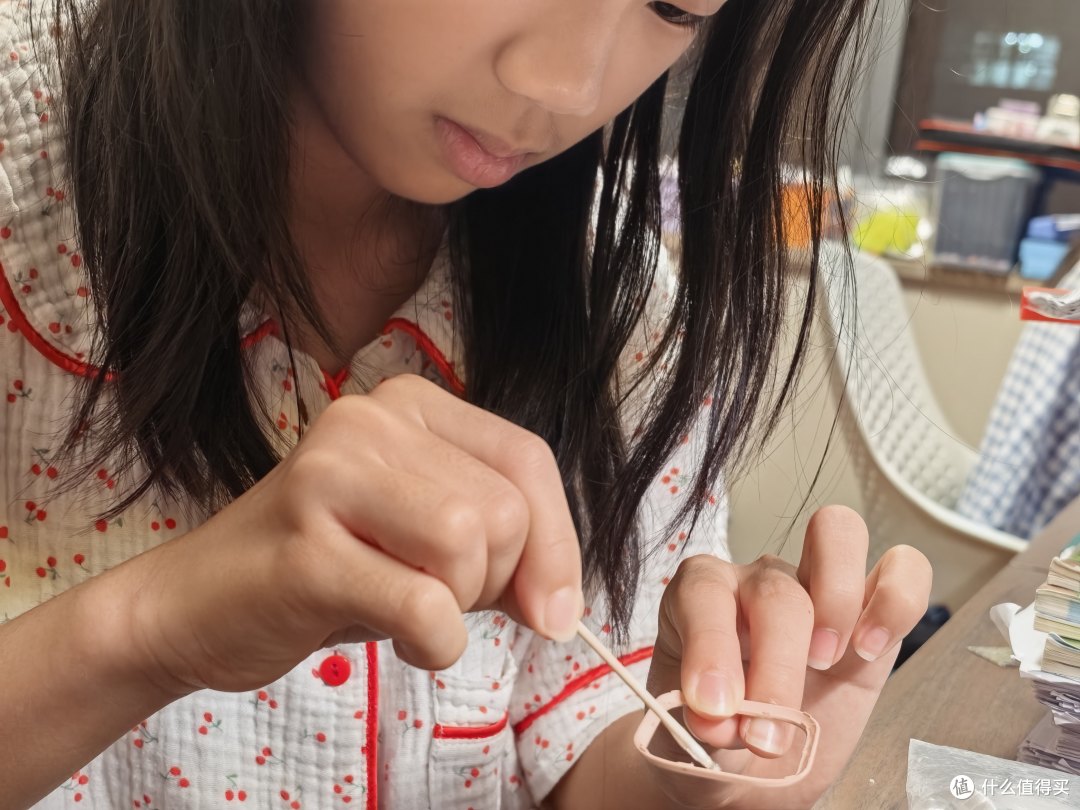 女儿用棉签沾着胶水往屏幕外框中涂胶水，这是我见过她最专注的一刻——比看动画片还专注
