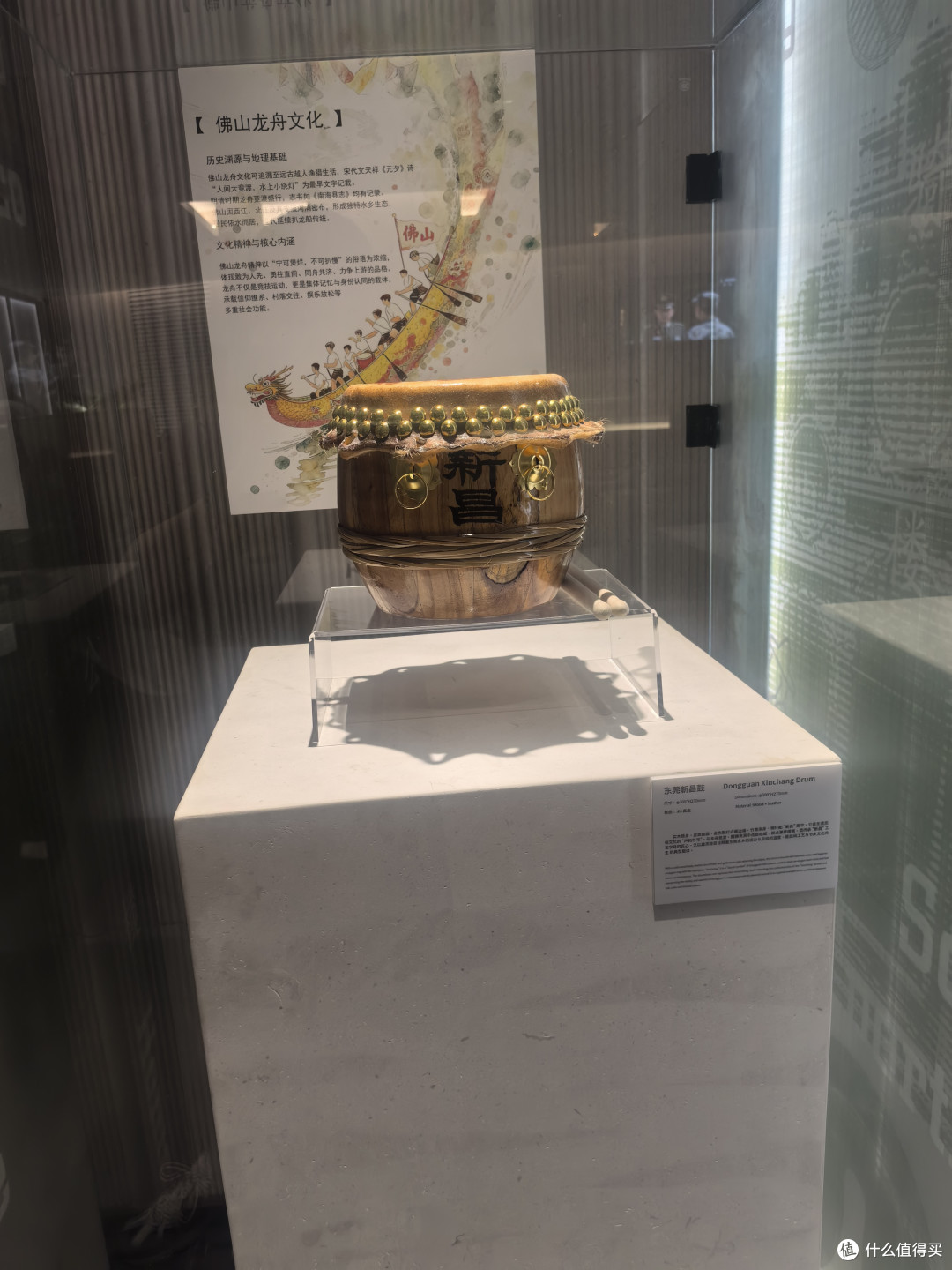 厅的边上有着展柜里摆放着广东的特色龙舟文化的龙舟头和鼓