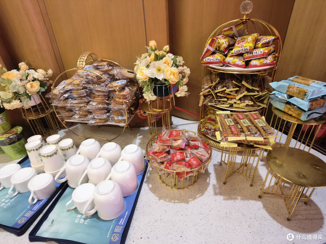 零食区里有热水、普耳茶，泡面、咪咪、饼干、沙琪码等，下面的柜子上摆放着饮用水、碳酸饮料